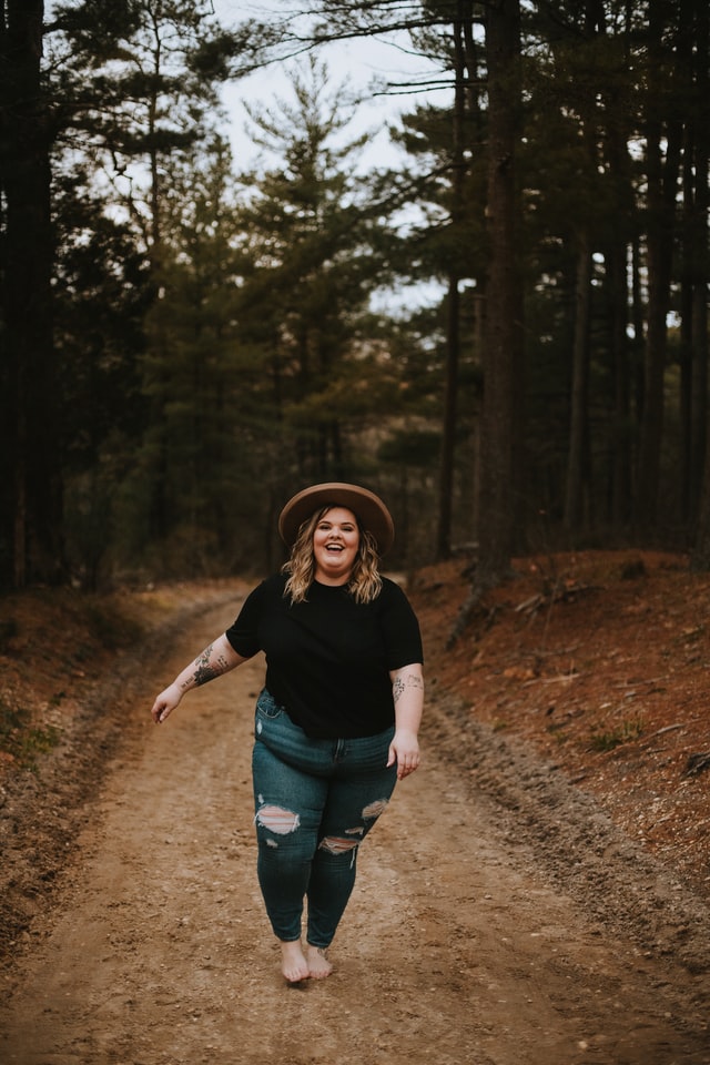 Mulher feliz caminhando pela pista de terra